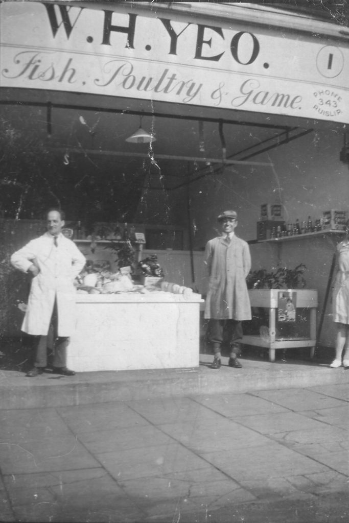 Wilfred Yeo (wearing a white coat) outside his fishmonger’s shop in Ruislip. Photograph from Don Short.